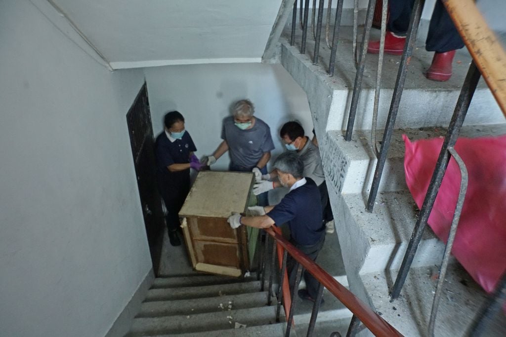 由於住家屬於老舊公寓，沒有電梯，慈濟志工得分組，才能將大量的囤積物品做適當的處置。