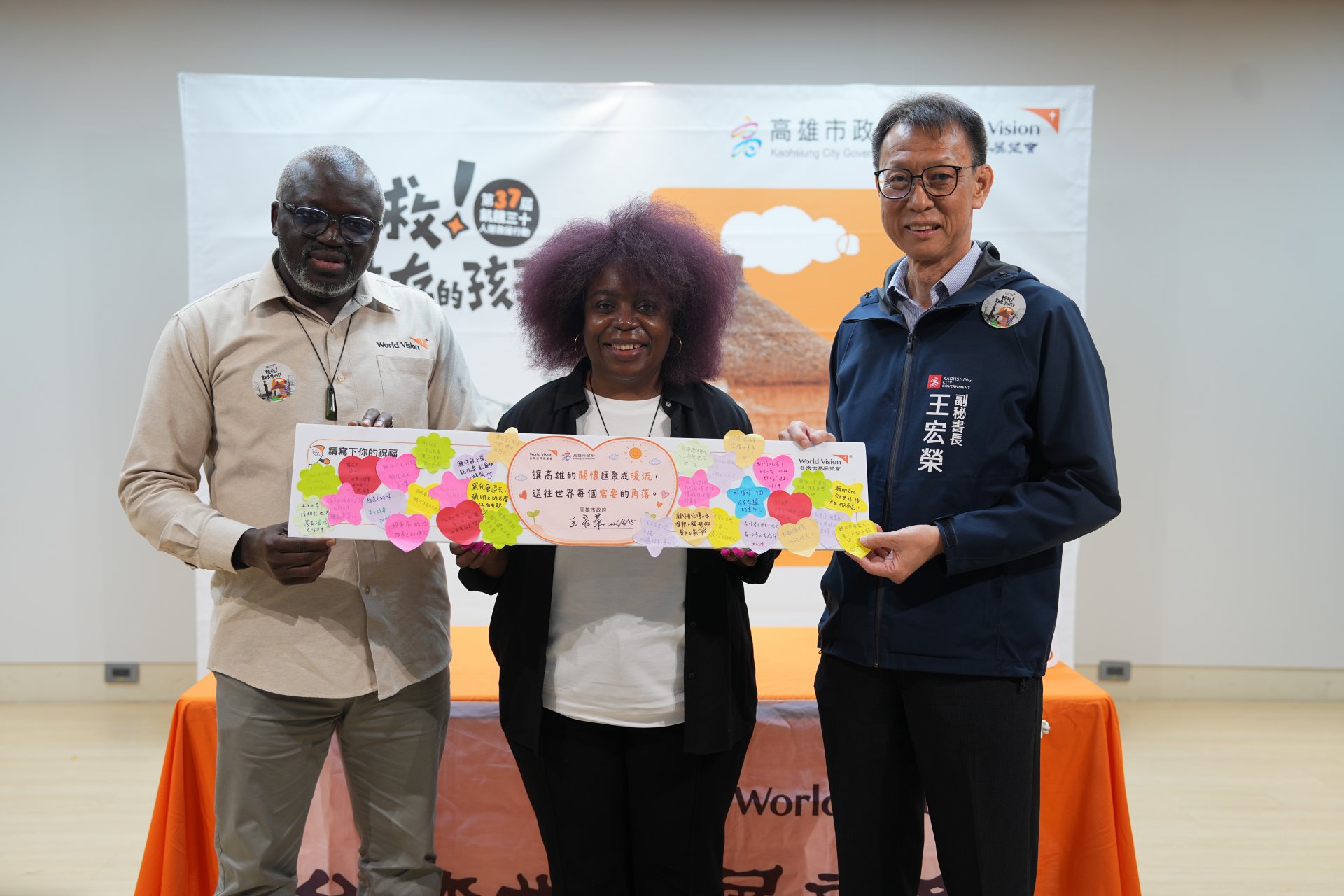 高雄市政府王宏榮副秘書長致贈「給難民的一句話」祝福卡予世界展望會東非總監莉莉安．多佐（Lilian Dodzo）及蘇丹世界展望會會長西蒙．馬內（Simon Mane），傳遞對全球難民與脆弱