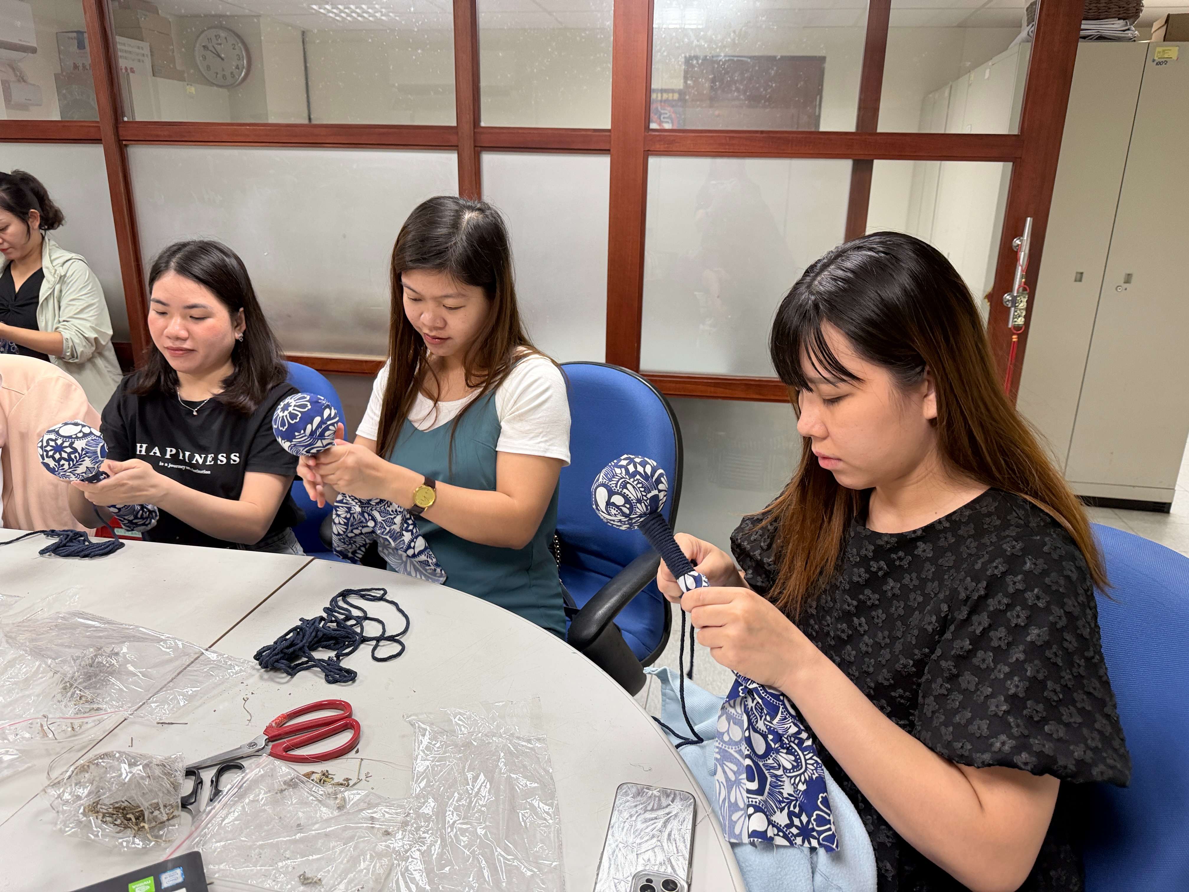 新住民小翠(右一) 專注製作艾草槌棒，期盼能寄回越南送給祖母紓壓。