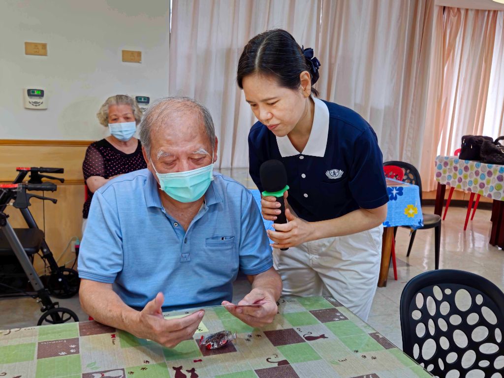 余伯伯抽到一張靜思語，志工蔡承汝為他解讀，長者說道：「這都是勸大家行善的好話。」