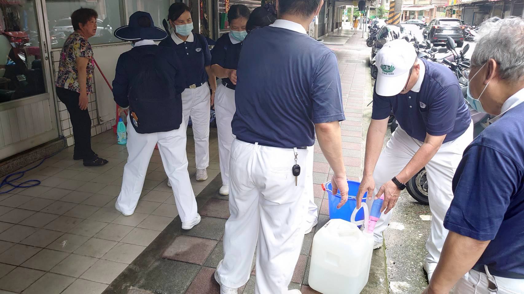 志工使用機具中,細心檢查零件,以備操作時順暢。更貼心為居民所需裝罐次氯酸水。
