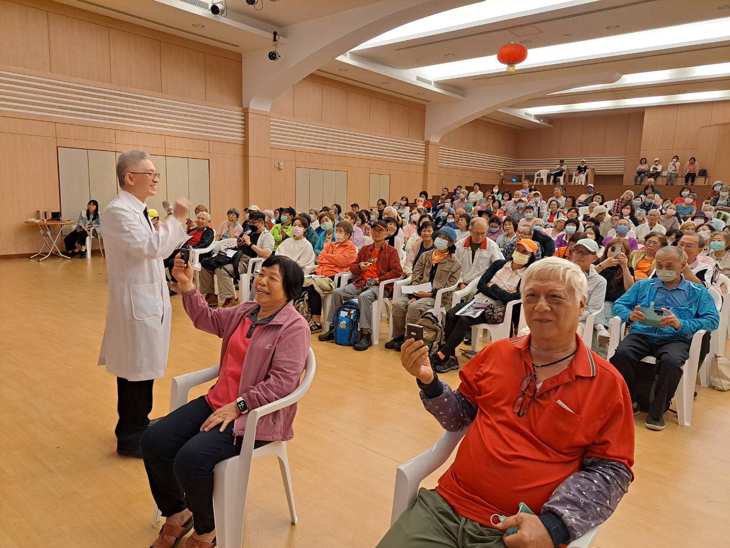 李嘉富醫師在演講中,邀請兩位長輩測試情緒波動感知。