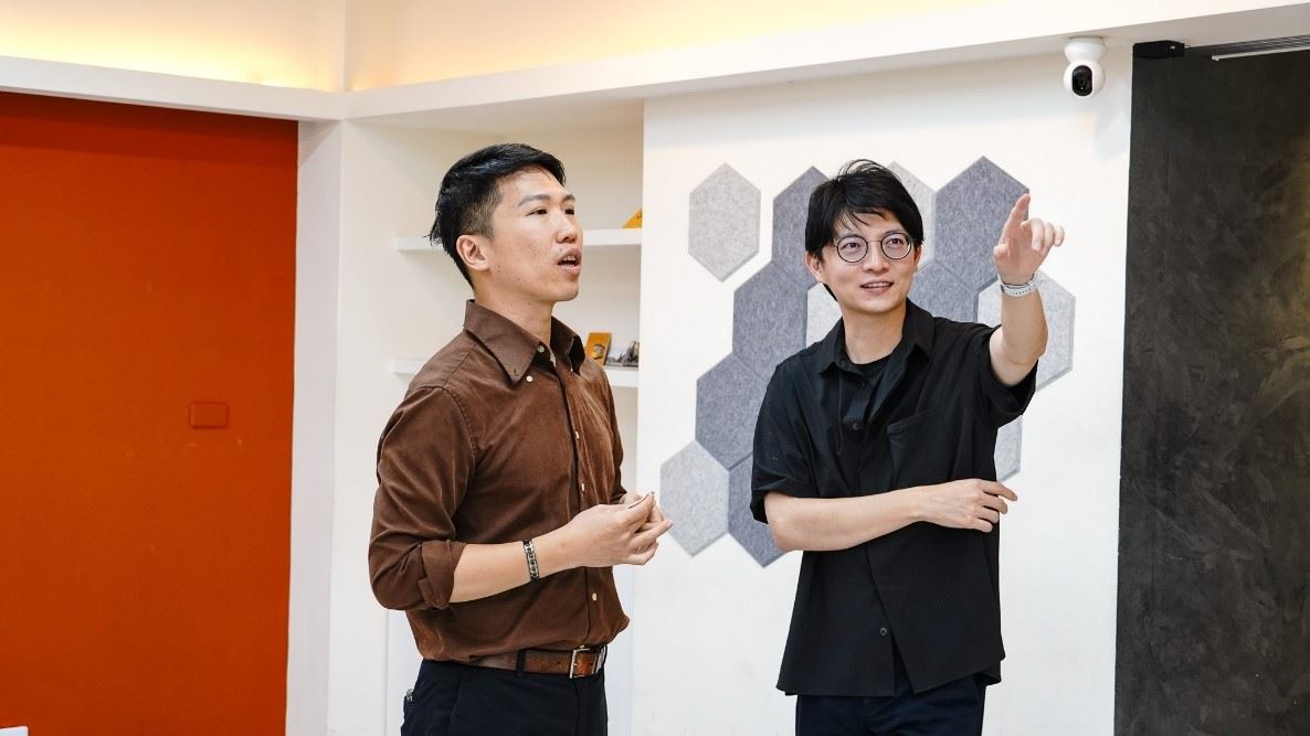 青創店家「高雄騷莎動」創辦人溫志中(左)向青年局長林楷軒(右)介紹透過青創補助升級的教室空間,展現政策支持對場域升級的實質效益。