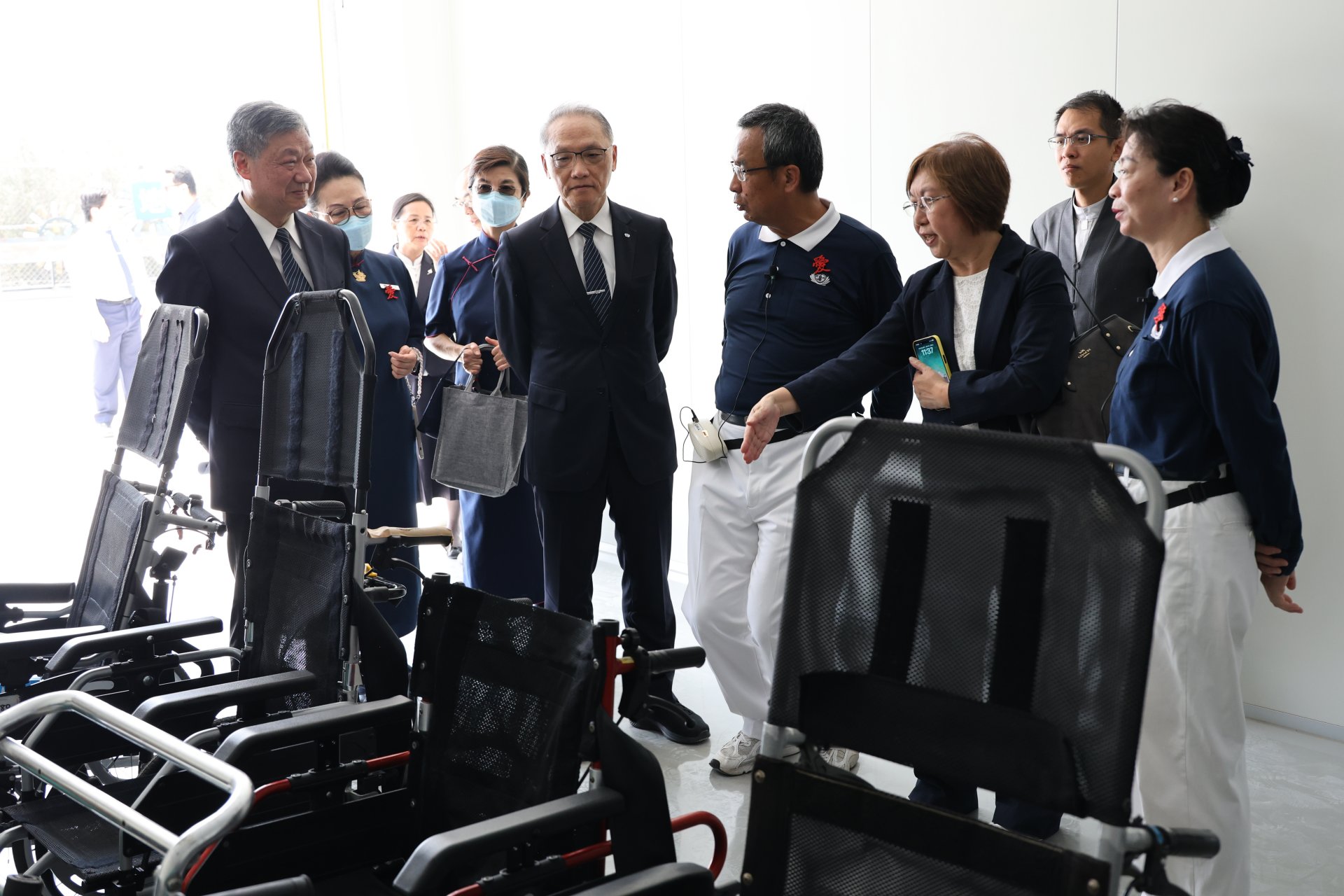 志工向慈濟顏博文執行長(左二)與社家署張美美副署長(右二)說明紫外線消毒室作業流程。