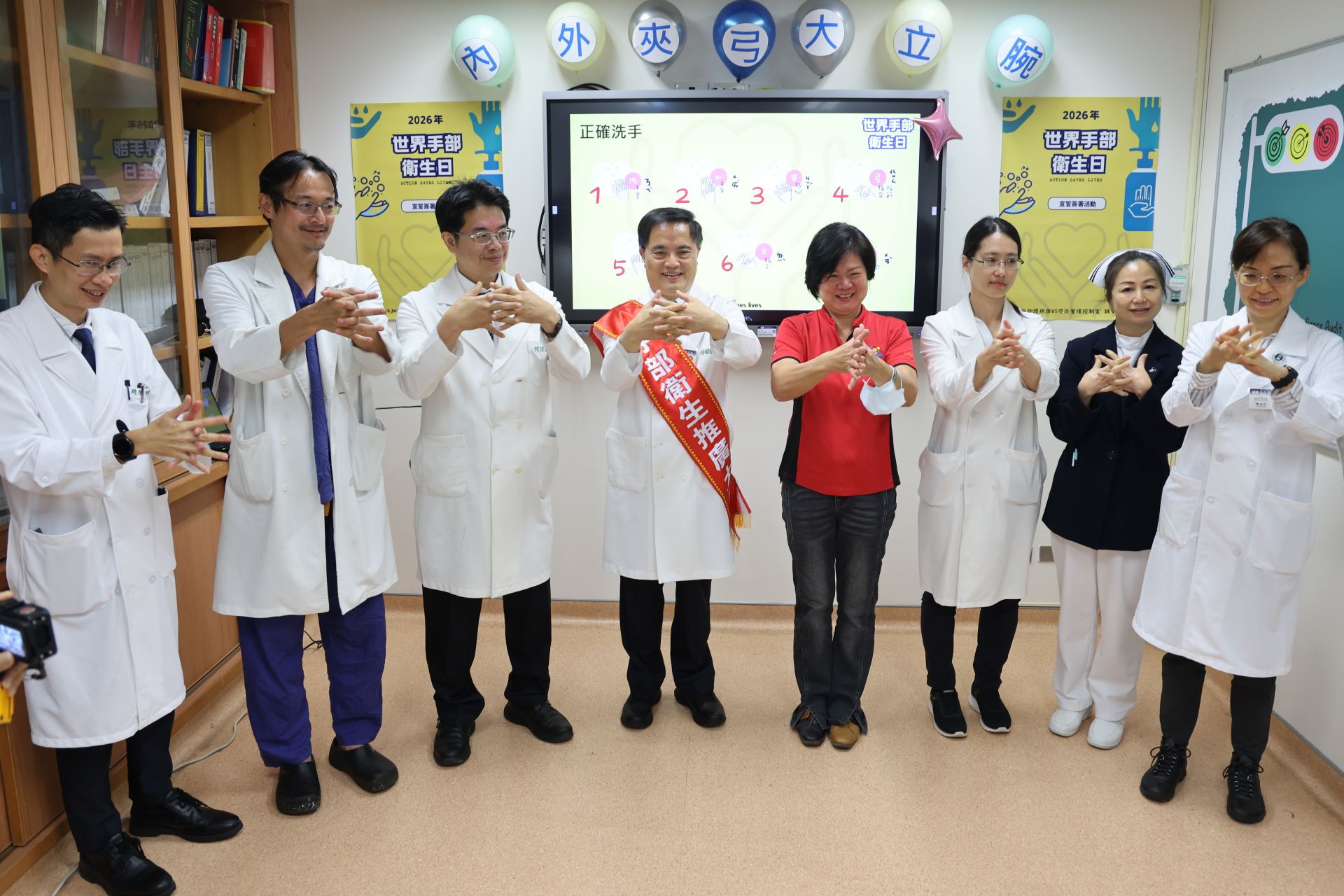 林欣榮院長(左四)、疾病管制科科長陳志櫻(右四)等人帶領現場同仁示範洗手七字訣「內、外、夾、弓、大、立、腕」。
