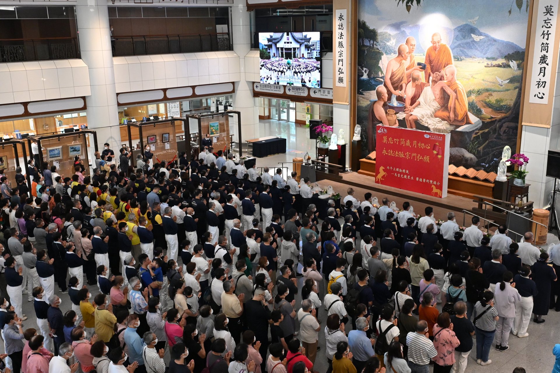 社區大德與住院病人及家屬齊聚醫院大廳，在醫療場域中共同浴佛祈福，感受這份溫馨與祝福。