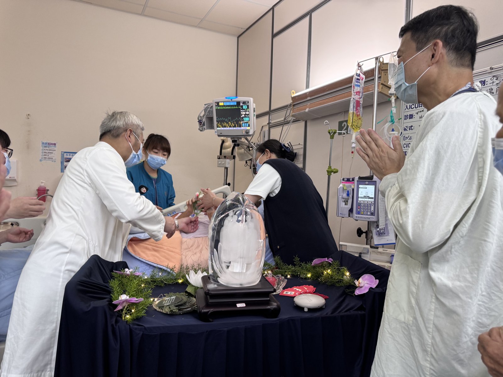 陳金城副院長（左）等人至加護病房，讓行動不便的病人能就近參與浴佛