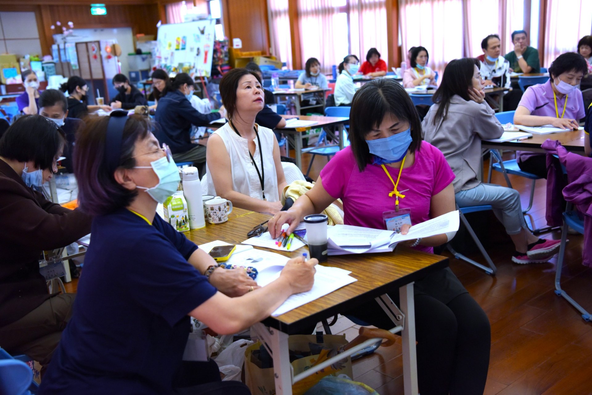 測驗涵蓋「學科筆試」與「術科考試」,甚至包含「臨場模擬」環節,模擬學員在面對真實社區長者時的指導情境與應變能力,學員勤作筆記。