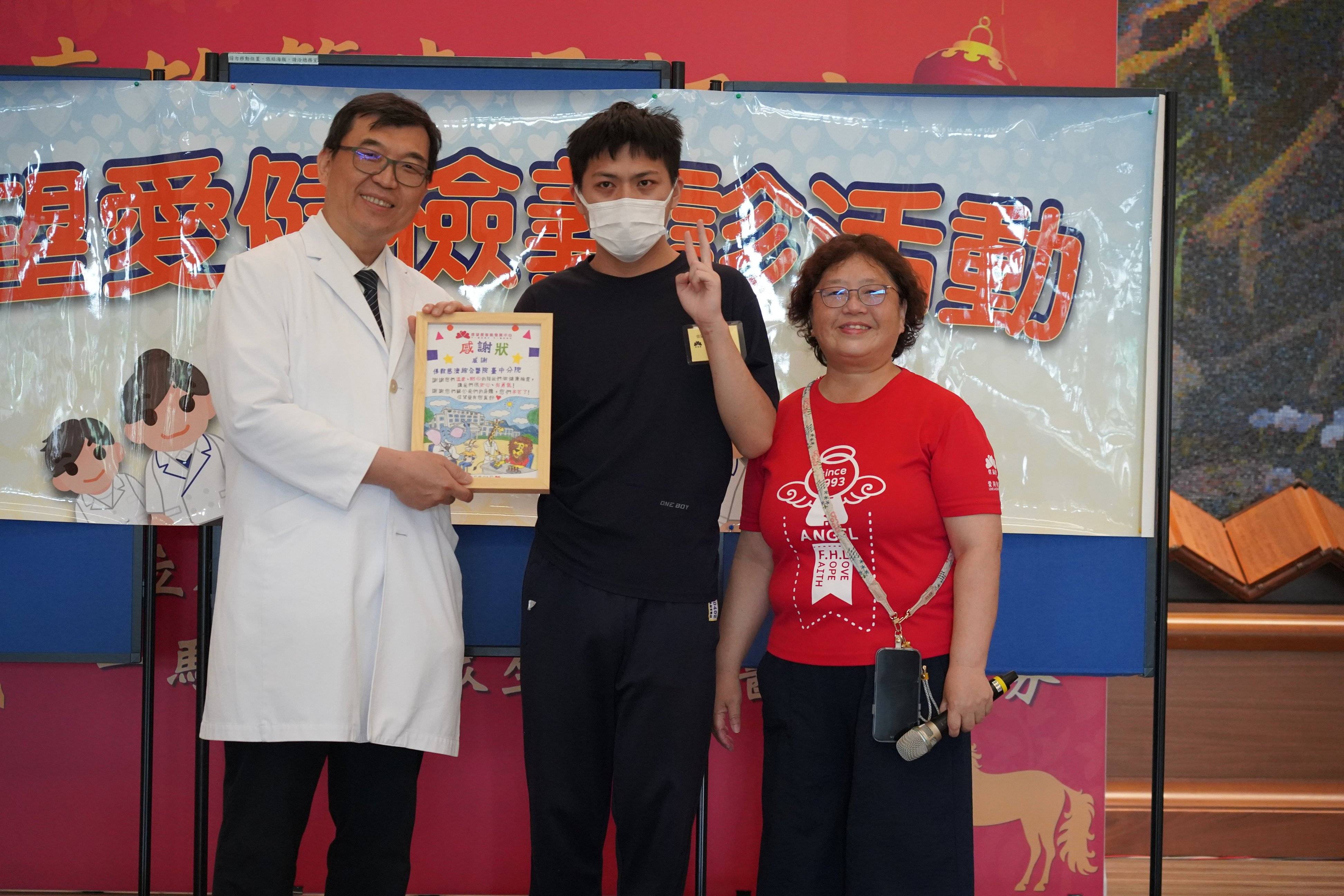 院生（中）將親手繪製的感謝狀致贈台中慈濟醫院，由醫務秘書林英超（左）代表受贈，信望愛智能發展中心副執行長趙淑珍（右）一同見證這份延續廿年的情誼。