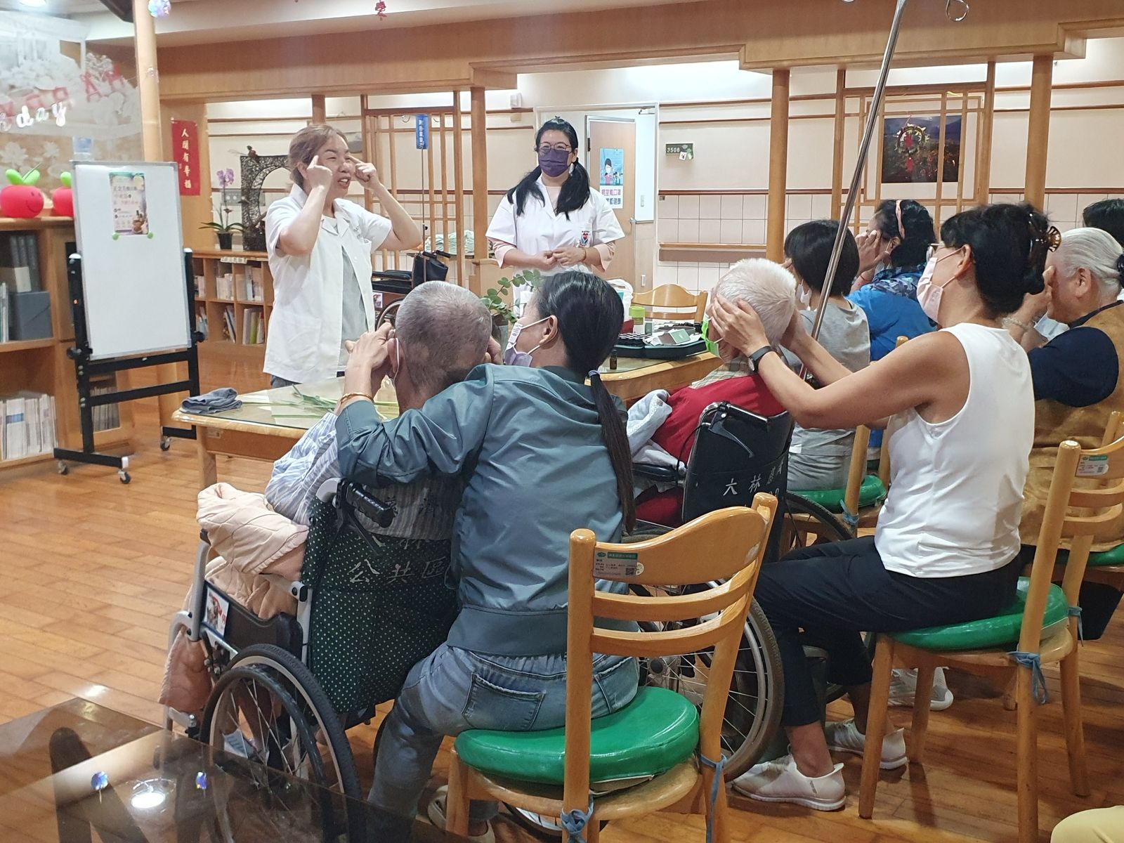 正念芳療講師陳淑真帶領病友及家屬學習臉部穴道按摩技巧