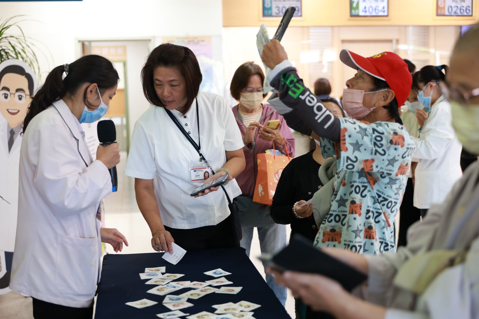營養科謝淳雅營養師與門診大聽民眾,透過衛教有獎徵答,兌換毛豆豆漿卡士達蛋糕。