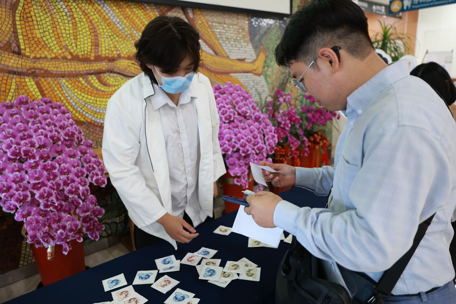 營養科謝淳雅營養師與門診大聽民眾,透過衛教有獎徵答,兌換毛豆豆漿卡士達蛋糕。